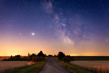 Weg im Feld zur Galaxie Milchstraße mit Planeten Saturn und Jupiter im Sommer