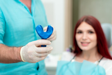 Doctor orthodontist shows the patient the result of the casts of her teeth