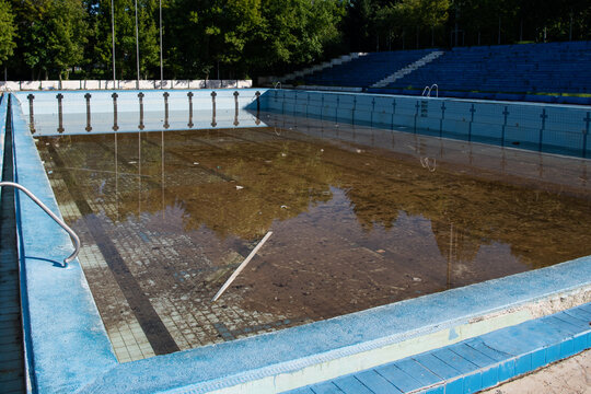 Damaged swimming pool. Old swimming pool with dirty water