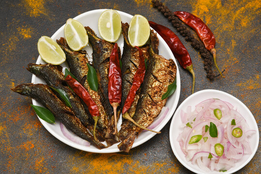 Bengali Sardine or pilchard fry fish curry with salad tasty sea food cuisine, Kerala India. Popular dish in Indian coastal area restaurants Kochi, Goa.