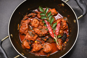 Kerala fish curry Alappuzha, India, Hot and spicy homemade red fish Masala curry on jute background. using king fish, red chilli powder, gambooge, turmeric. Top view non veg Indian side dish food.

