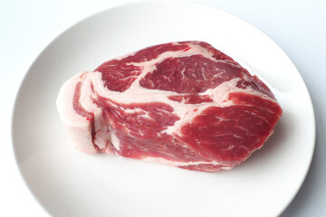豚肩ロースのブロックと白い皿