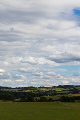Fototapeta na wymiar hügelige Landschaft mit Wolkenhimmel