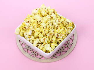 Tasty popcorn in a bowl isolated on Pink Background. Snack for a movie