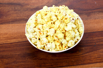 Tasty popcorn in a bowl on Wooden Background. Snack for a movie