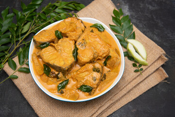 Kerala fish curry, spicy and hot king fish curry with green curry leaf Kerala India. Top view Barracuda Fish curry with green chili, coconut milk and mango Asian cuisine.