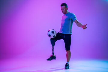 Athlete with disabilities or amputee on gradient studio background in neon. Professional male...