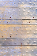 Altes abgewitterte Metall mit Noppen in Silber und Gold als Hintergrund