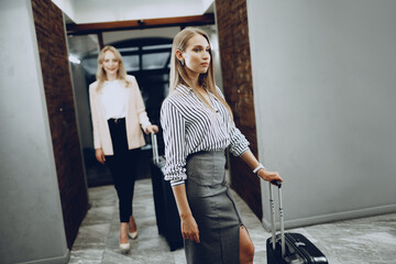 Two young women in formal clothes entering hotel lobby