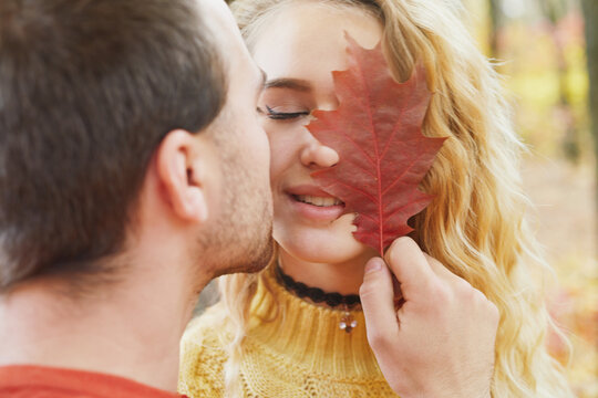 Young happy couple relaxing and loving in the autumn forest at sunset.