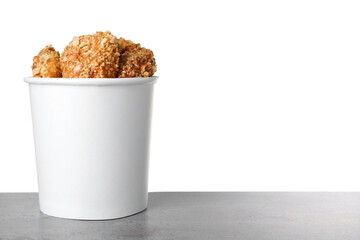 Bucket with yummy nuggets on dark table against white background, space for text