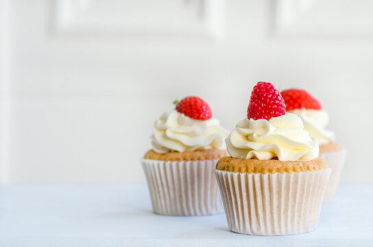 Home Baked Cupcakes With Red Berries and Butter Cream Frosting