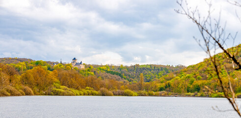 autumn landscape in the forest with a huge castle on a lake