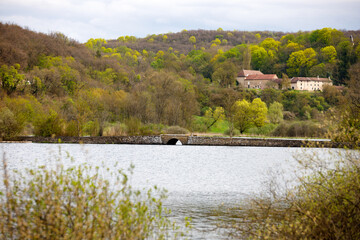 landscape with bridge on a lake with an enormous building on the countryside