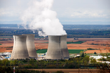smiking cooling towers of a nuclear power plant in the coutryside