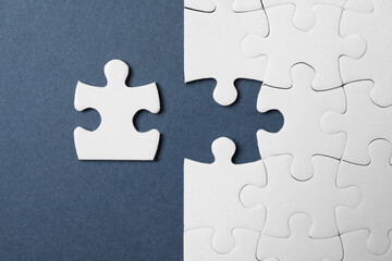 Obraz premium Blank white puzzle with separated piece on grey background, flat lay