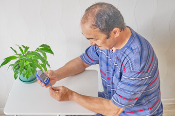 Senior man checking blood sugar level
