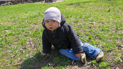 little boy sitting on the grass