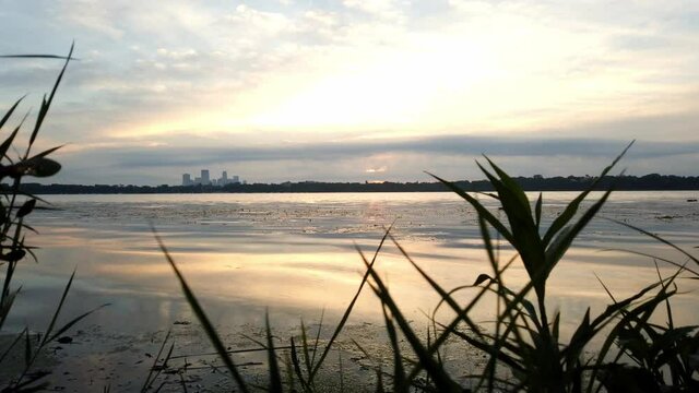 time lapse during a cloudy morning by the lake skyline of downtown minneapolis in the backgrand