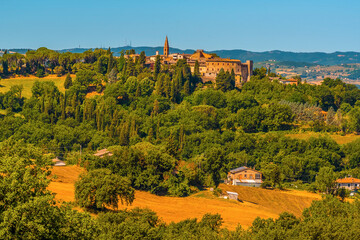 Naklejka premium The village of Collazzone situated above the rolling hills of Umbria near Todi, Italy in summer