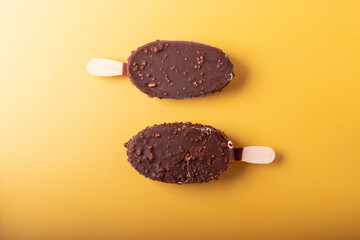 tasty cold chocolate ice cream with nuts pieces on wooden stick