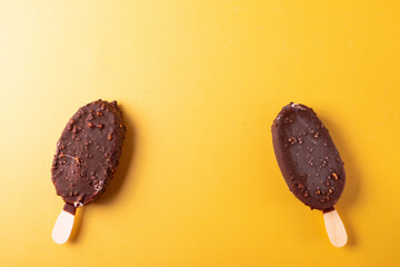 tasty cold chocolate ice cream with nuts pieces on wooden stick