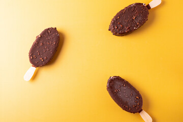 tasty cold chocolate ice cream with nuts pieces on wooden stick