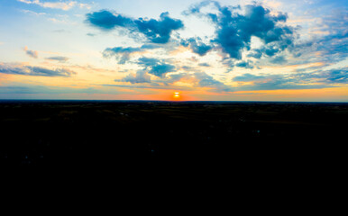 Panoramic aerial view of beautiful green tropical forest with mountains and majestic blue sky and clouds. Sunset