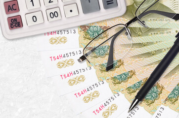 1 Chinese yuan bills fan and calculator with glasses and pen. Business loan or tax payment season...
