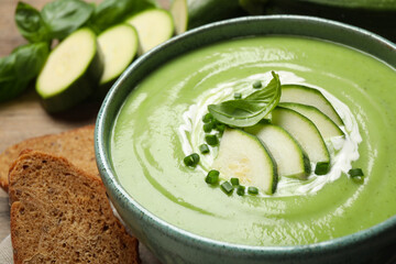 Tasty homemade zucchini cream soup in bowl on table, closeup