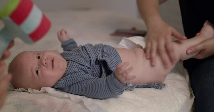 View of little baby lying on bed during the massage therapy