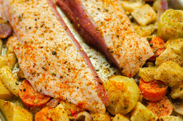 Raw duck breast with vegetables prepared on a metal baking tray