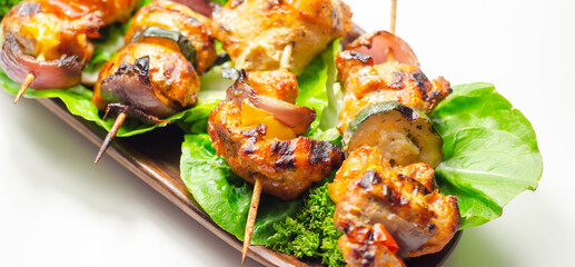 Grilled skewers with chicken, zucchini, mushrooms, peppers and onions served on iceberg lettuce
