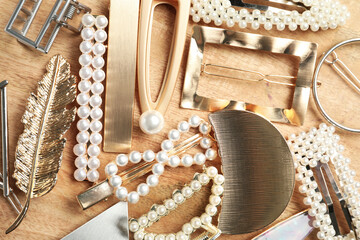 Stylish hair clips on wooden table, flat lay