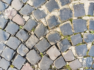 Close-up old paving stones. Cobbled street in Lviv, Ukraine. Old broken paved street. Pavement of stones. Granite cobblestones on pavement. Stone cement tile curving texture street.