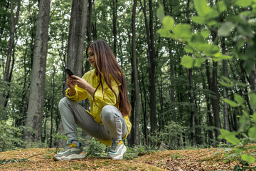 Female traveler uses a smartphone in a spring forest