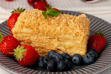 Piece of russian honey cake medovik served with berries