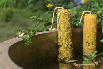 The background image has a yellow paint roller. Yellow flowers are on the edge of the basin.
