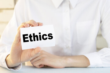 Businessman holding a card with text ethics