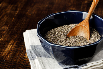 Chia seeds in a bowl with wooden spoon