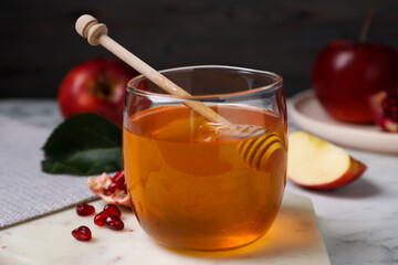 Honey, apples and pomegranate seeds on white marble table. Rosh Hashanah holiday