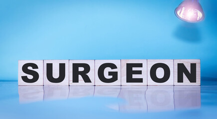 Surgeon inscription on wooden cubes on a blue background. Medical concept.