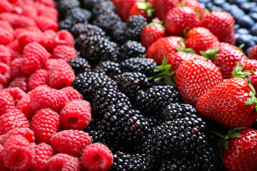 Mix of different ripe tasty berries as background, closeup view