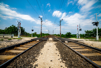 train railroad tracks in the countryside with electric power in lines vivid color