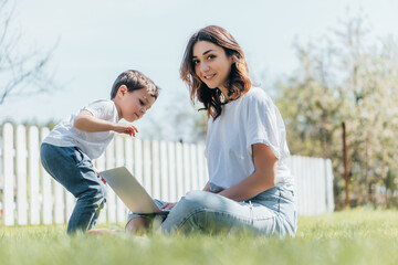 selective focus of happy freelancer using laptop near cute son