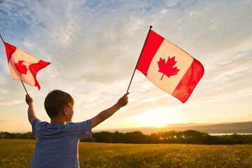 Adorable cute happy Caucasian boy holding Canadian flag on the father shoulder