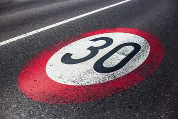 30km/h speed limit sign painted on asphalting road. - obrazy, fototapety, plakaty