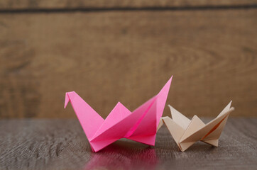 two origami cranes on wooden
