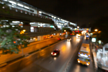 Abstract blurred traffic city of Night market on street light bokeh background. Bangkok, Thailand Cityscape at twilight time concept: focus in Motion blur,  Modern business building estate nightlife.