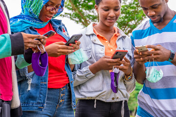 group of young black people using their mobile phones simultaneously